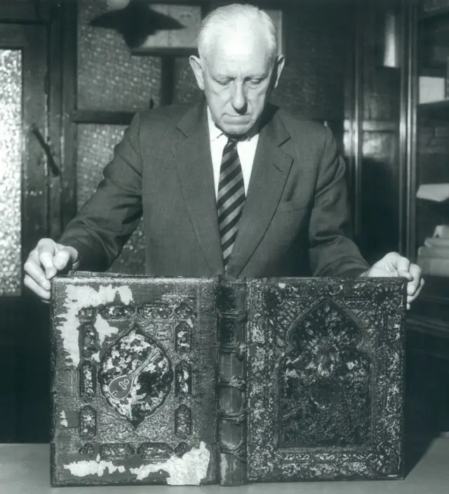 ستانلي براي يحمل ما تبقى من الكتاب الثاني الذي تعرض لأضرار بالغة في الغارات الألمانية