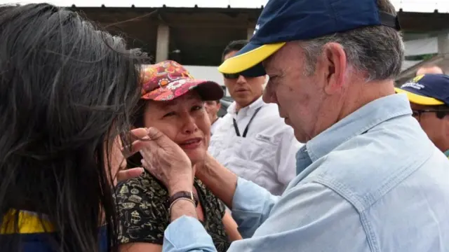 பாதிக்கப்பட்ட பெண்மணி ஒருவரை தேற்றும் அதிபர் குவன் மனுவேல் சான்டோஸ்