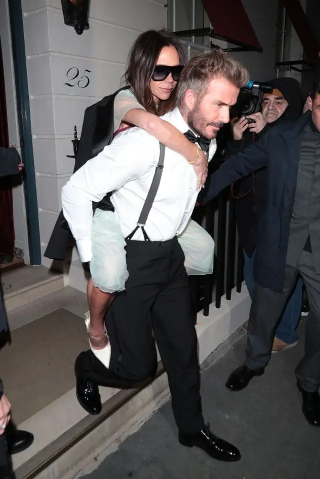 دیوید بکهام در حالی که ویکتوریا را از مهمانی بیرون می آورد