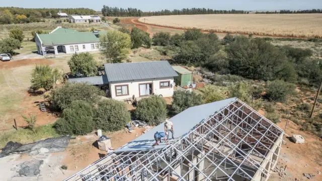 Güney Afrika'nın Orania bölgesinde bir çiftliğin çatısı iki beyaz tarafından onarılıyor