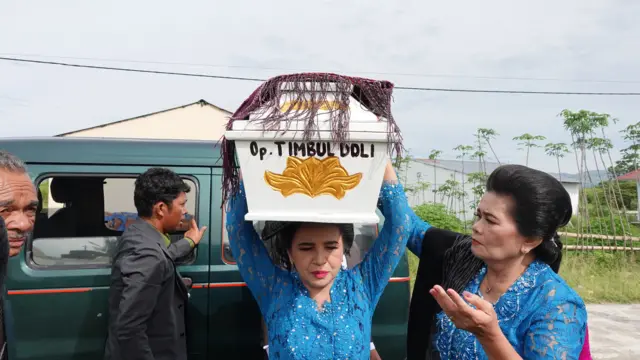 Pengangkatan peti dalam prosesi mangongkal holi.