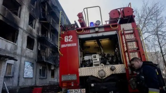 रशियन हल्ल्यांमुळे इमारतींना लागलेली आग विझवताना अग्निशमन दलाचं पथक.