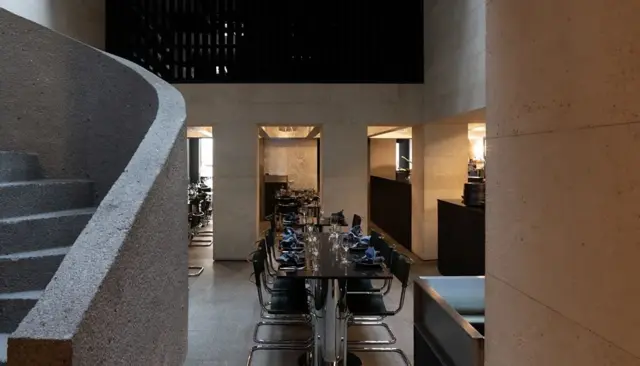 Uma foto do salão do restaurante com mesas e cadeiras