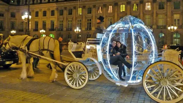 Una pareja en una carroza como la de la Cenicienta, tirada por caballos