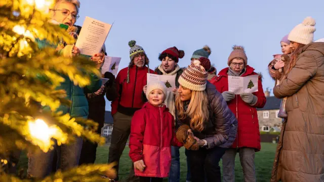 Grupo de personas cantando villancicos 
