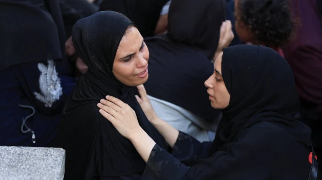 سيدة تواسي سيدة أخرى في مدينة غزة