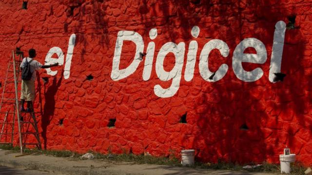海地太子港市郊佩蒂翁維爾一名工人在牆壁上畫上Digicel廣告（資料圖片）