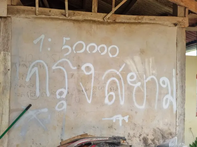 ภาพพ่นสีสเปรย์ผนังบ้านหลังหนึ่งในบ้านหนองจาน ต.โนนหมากมุ่น อ.โคกสูง จ.สระแก้ว ซึ่งเป็นจุดกระทบกระทั่งชายแดนรอบล่าสุด ระหว่างมวลชนชาวกัมพูชากับเจ้าหน้าที่ฝ่ายความมั่นคงของไทย ภาพนี้ถ่ายโดยนายสุภลักษณ์ กาญจนขุนดี เมื่อวันที่ 2 ก.ย. 2568