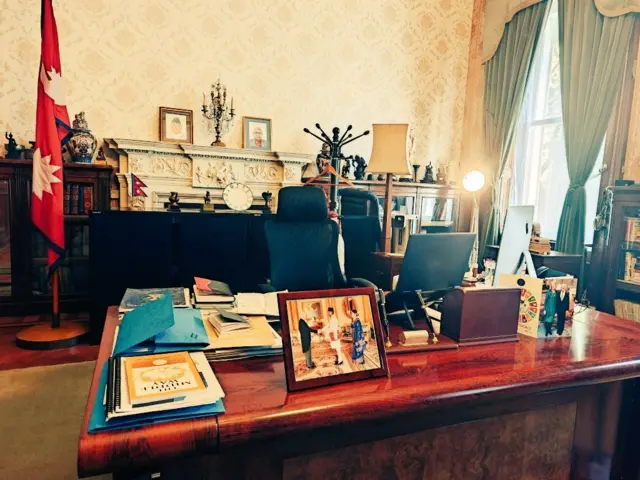 यूकेस्थित नेपाली राजदूतको कार्यकक्ष, पृष्ठभूमिमा नेपालको झण्डा पनि देखिन्छ 