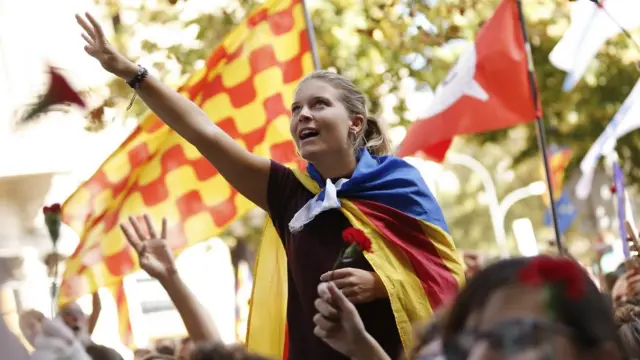 కాటలోనియా పతాకంతో అభివాదం చేస్తున్న యువతి