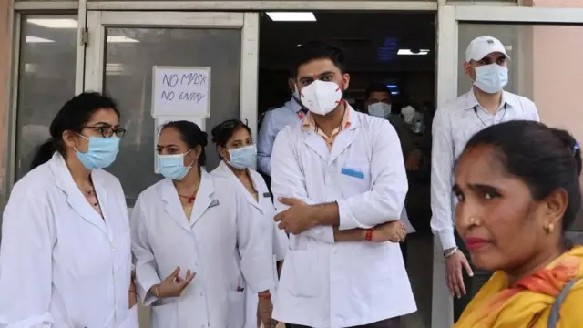 Healthcare workers wait for the health minister's inspection, outside the hospital building as coronavirus disease (COVID-19) cases rise in the country, in New Delhi, India, April 10, 20