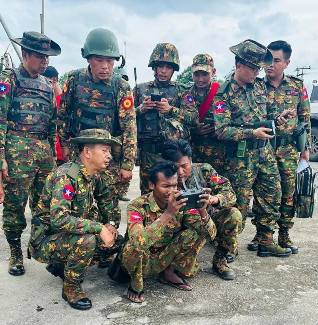 ဒရုန်းလွှတ်နေတဲ့ စစ်သားတွေနဲ့ စစ်ဆင်ရေးကို လမ်းဘေးမှာ အတူတူကြည့်နေတဲ့ ဒုတိယဗိုလ်ချုပ်ကြီးနိုင်နိုင်ဦး (ပုံဟောင်း)