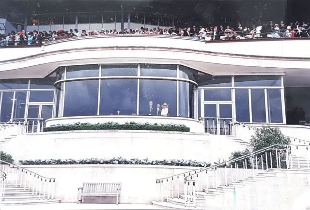 һ�Ź����Ƭ��ʾһ�����Ͱ�ɫ���������в�����������˹̹������³�����˹����վ������һ�ȴ�ǰ�������Ϸ�����Ⱥ