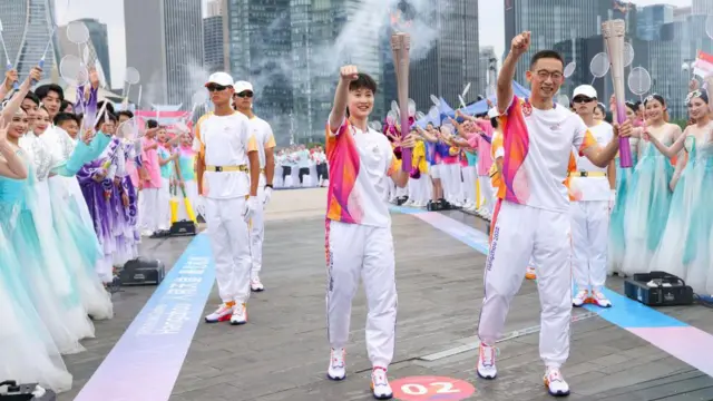 Pemain bulu tangkis Tiongkok Chen Yufei (kiri) dan presiden Universitas Westlake Shi Yigong berpose untuk foto dengan obor saat estafet obor Asian Games ke-19 pada 20 September 2023 di Hangzhou, Provinsi Zhejiang, China