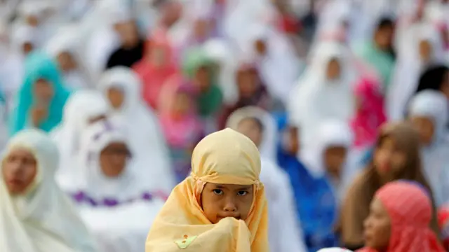 As prayer go soon start for Jakarta, Indonesia, people dey wait for outside the mosque