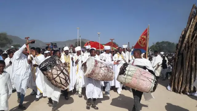 ካህናትን ዲያቆናትን ከረን ብጸናጽልን ከበሮን ተሰንዮም ኣብ ዙርያ ዳሜራ እናኾለሉ