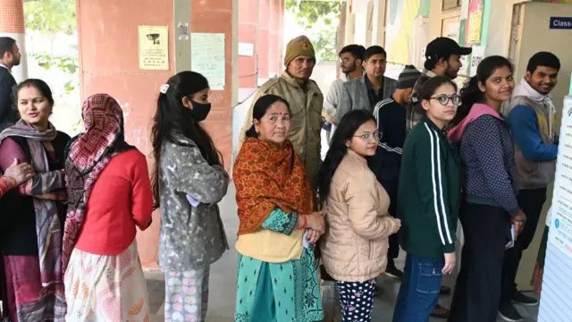 वोट डालने के लिए लाइन में लगे लोगों की तस्वीर