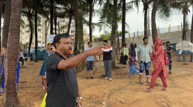 బీచ్ నుంచి ప్రజలను పంపించేస్తున్న సిబ్బంది