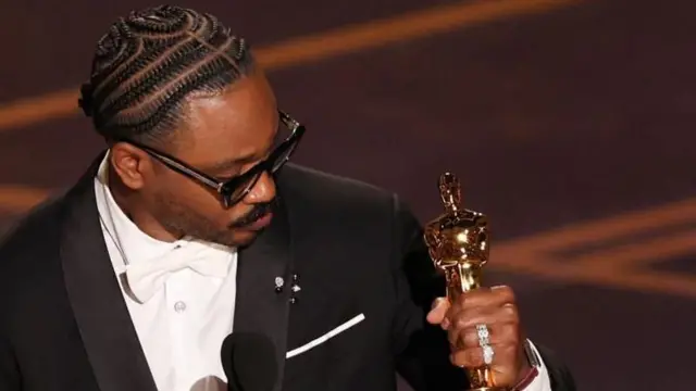 తన సినిమా ‘సిన్నర్స్’కు ‘బెస్ట్ ఒరిజినల్ స్కీన్‌ప్లే’ విభాగంలో లభించిన ఆస్కార్‌ను చేతిలో పట్టుకున్న అమెరికా దర్శకుడు, నిర్మాత రెయాన్ కూగ్లర్