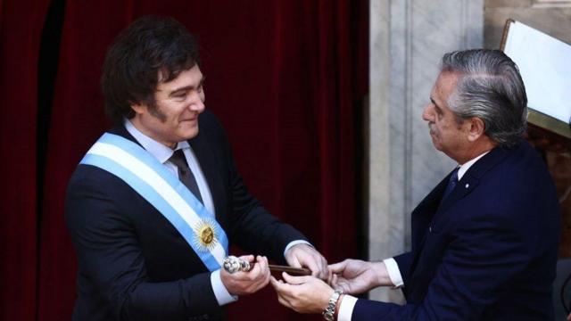 El presidente saliente de Argentina, Alberto Fernández, le entrega el bastón presidencial a Javier Milei 