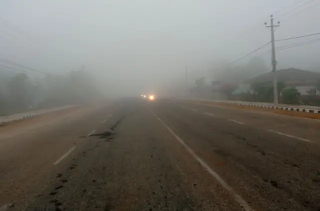 यो हप्ता महोत्तरीमा बिहान देखिएको हुस्सु। बत्ति बालेर गुडिरहेका केही सवारी साधन पनि देख्न सकिन्छ।