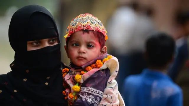 इलाहबादमध्ये सेरेब्रल पाल्सी पीडित मुलांसाठी होळीचे आयोजन करण्यात आले होते. यावेळी होळी खेळण्यासाठी आपल्या मुलाला घेऊन जाताना एत मुस्लीम महिला (25 फेब्रुवारी)