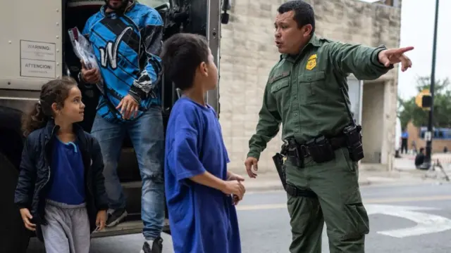 Un agente fronterizo da instrucciones a unos niños