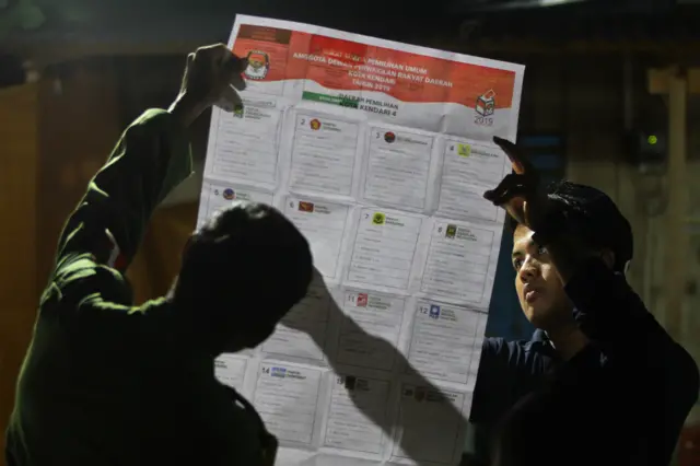 Petugas KPPS melihat tanda bukti pencoblosan pada perhitungan hasil Pemungutan Suara Ulang (PSU) di TPS 24 Kelurahan Watubangga, Kendari, Sulawesi Tenggara, Sabtu (27/4/2019). Akibat pengunduran diri tiga anggota KPPS di TPS tersebut menyebabkan perhitungan suara sampai malam hari dan hujan deras juga menjadi penyebab mundurnya waktu perhitungan.