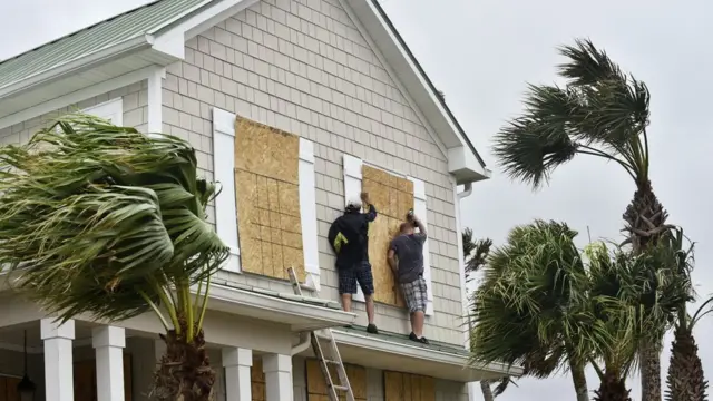Evlerinin pencerelerine tahta set çeken ABD'liler.