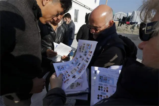 Мигранты читают листовки