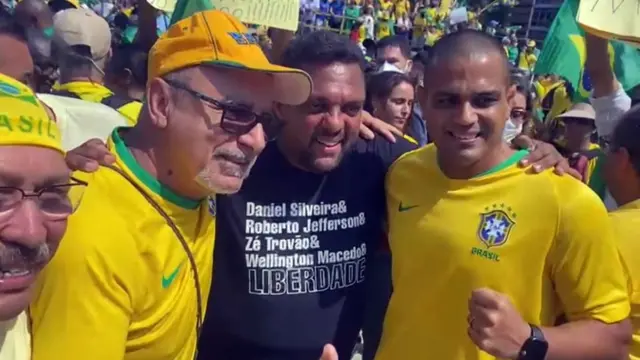 Queiroz posa para foto ao ladosportingbet ou betfairmanifestantes, um deles com camisa preta que diz: Daniel Silveira & Roberto Jefferson & Zé Trovão & Wellington Macedo & LIBERDADE