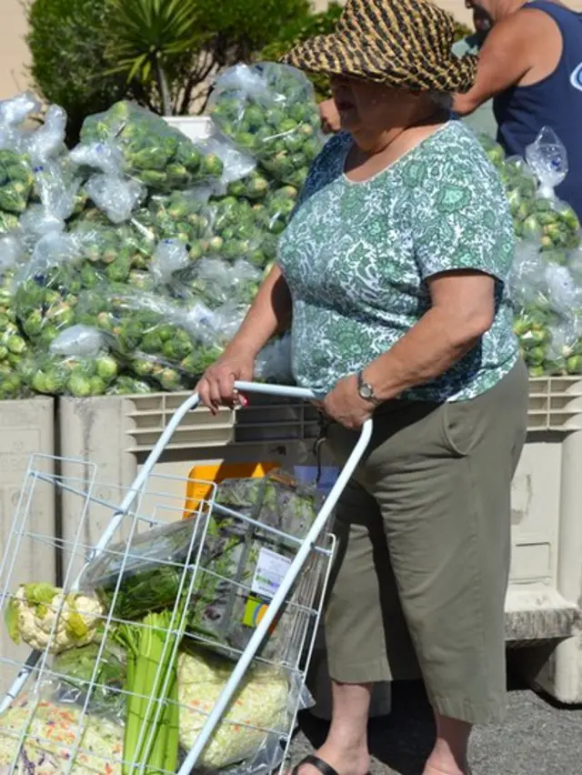 Señora recogiendo alimentos