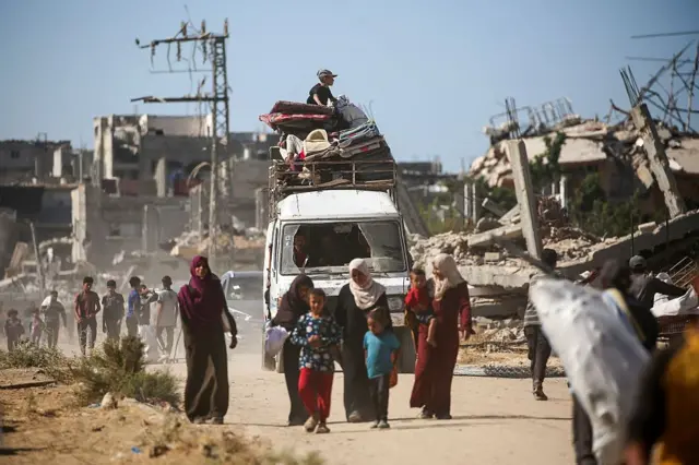 طفل يجلس فوق مركبة محملة بأمتعته، بينما يعود الفلسطينيون النازحون إلى منازلهم في منطقة الزهراء، شمال مخيم النصيرات للاجئين في وسط قطاع غزة، في 14 أكتوبر/تشرين الأول 2025، بعد يوم من دخول وقف إطلاق النار حيز التنفيذ.