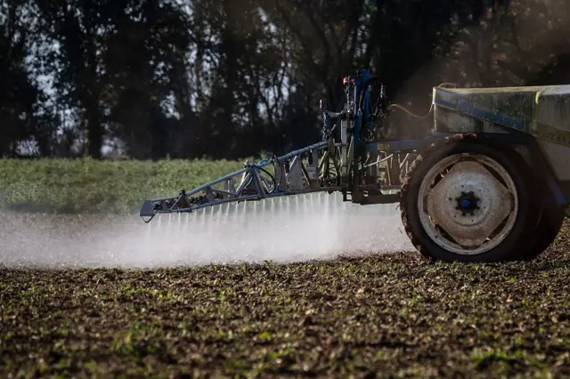 Trator aplica herbicida no em campo