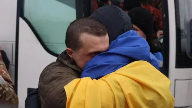 Звільнений полонений українець обіймається з чоловіком, який його зустрічає