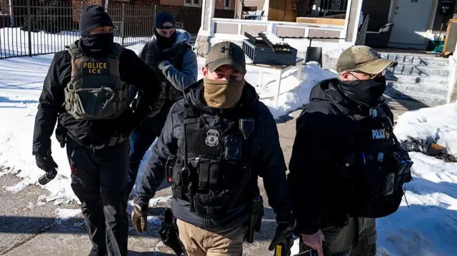 Agentes de ICE caminando frente a una casa en Minneapolis, Minnesota, el 28 de enero. 