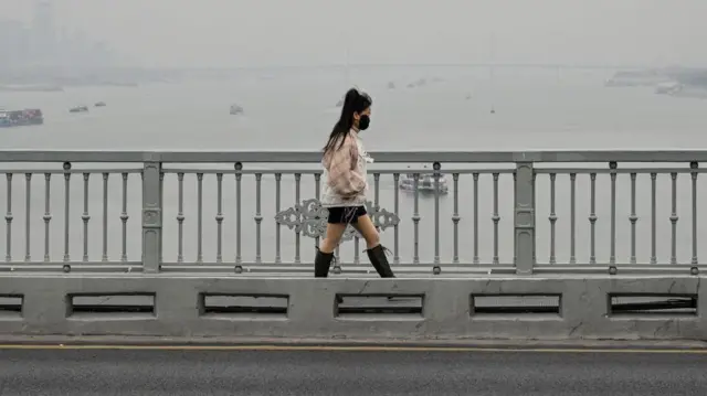 Una mujer camina por el puente de Wuhan sobre el río Yangtze en Wuhan, en la provincia central china de Hubei, el 22 de diciembre de 2024