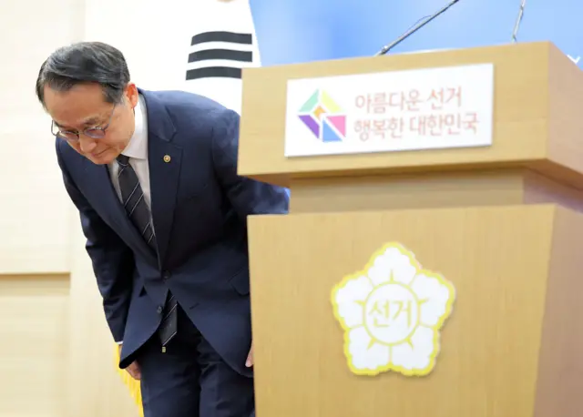 3일 서울에서 열린 기자회견에서 허철훈 중앙선거관리위원회 사무총장이 투표용지 부족 사태에 대해 공개 사과하고 있다. 태극기 앞에 선 허 총장이 정장 차림을 하고 고개를 숙이고 있다