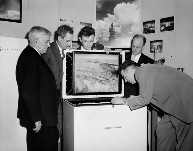 3 científicos, un empresario y un periodista viendo lo que pasa en un congelador.