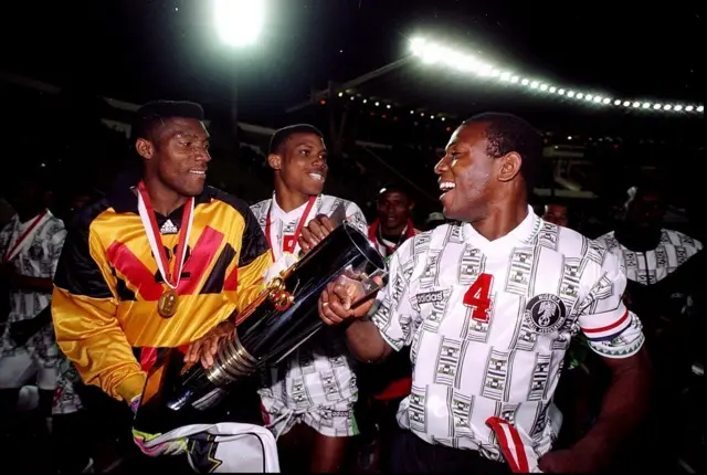 Peter Rufai, Stephen Keshi ati agbabọọlu Super Eagles kan re e, to n ṣe ajọyọ pẹlu ife African Nations Cup ti wọn gba lọdun 1996.