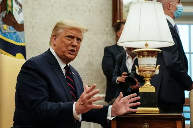 Donald Trump koyu bir takım elbiseyle konuşurken