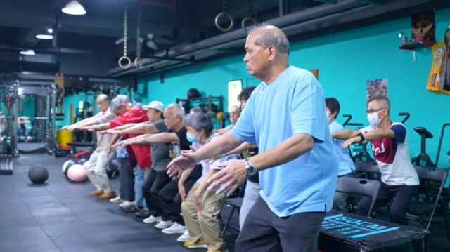 一群宏福苑居民在健身房中，正由健身教练领导进行体适能训练