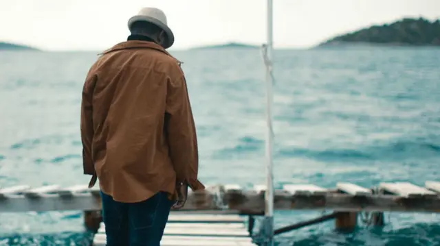 Un hombre de espaldas a la cámara frente al mar