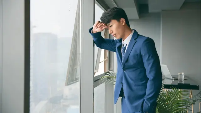 Sad young business man resting by the window
