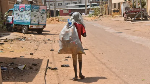 Wani yaro da ke sana'ar jari-bola da tsakiyar rana.