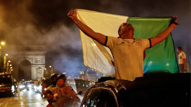 محتفلون وسط جادة الشانزيليزية في العاصمة الفرنسية باريس بفوز المنتخب الجزائري