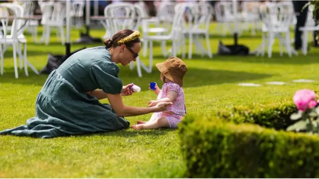 한 경마장 방문객이 호주 멜버른 플레밍턴 경마장에서 어린이에게 자외선 차단제를 발라주고 있다