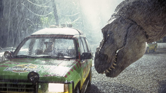 Cena de filme mostra um T. rex empurrando um carro com o focinho sob chuva pesada