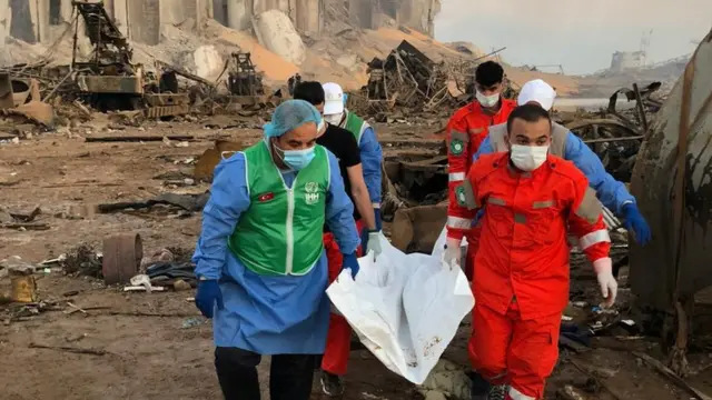 فريق انقاذ ينقل جثة من موقع الانفجار