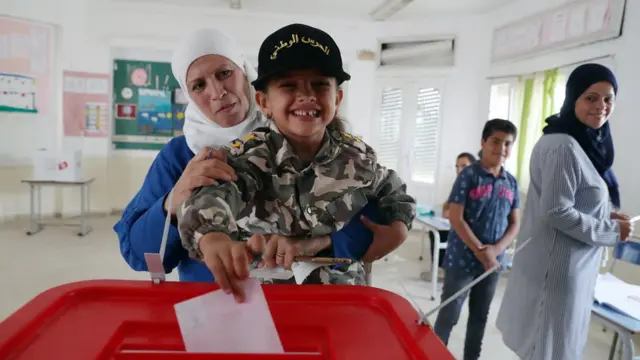 A woman has a child cast her ballot for her